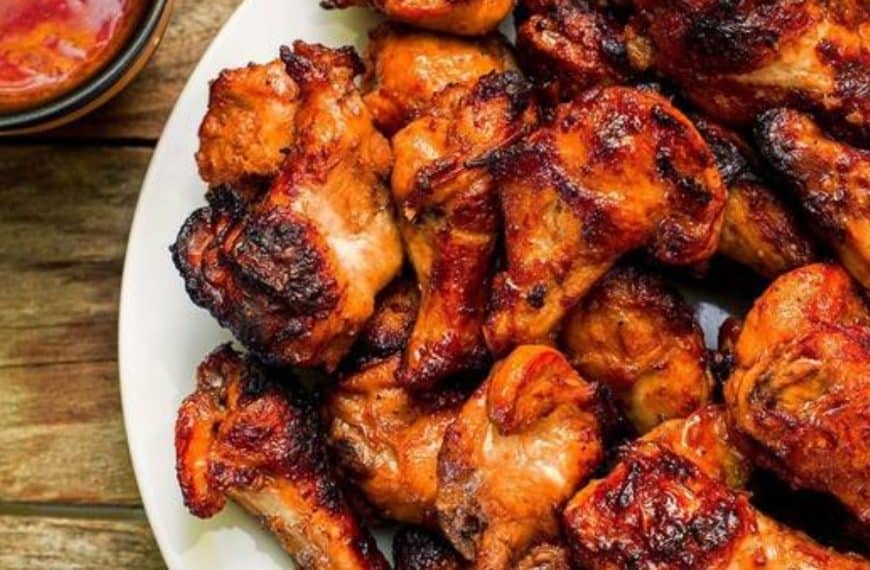 Succulent grilled chicken drumsticks with a flavorful roasted exterior, served on a white platter. Perfect for barbecues, gatherings, and flavorful dinner recipes.