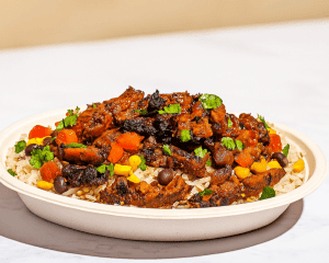 Savory beef stew served over rice with colorful vegetables, cilantro garnish, and rich tomato sauce, perfect for hearty comfort food meals.